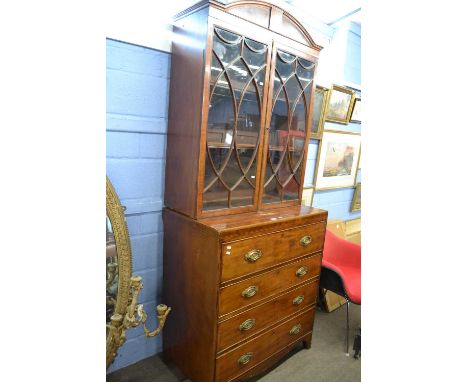 A Georgian mahogany secretaire cabinet with arched inlaid cornice over two glazed doors opening to a shelved interior, be bas