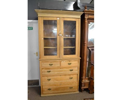 A Victorian light oak side cabinet with moulded cornice over two glazed doors opening to a shelved interior over a base secti