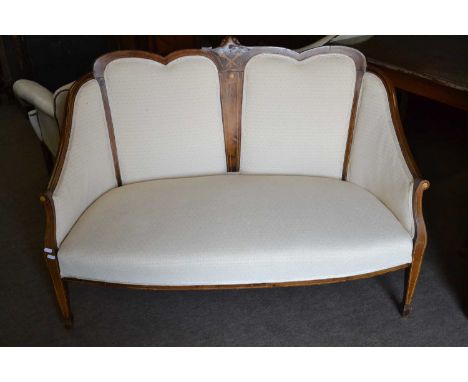 An Edwardian salon sofa with walnut veneered and inlaid frame and cream upholstery, raised on tapering legs with spade feet, 