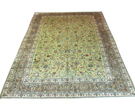 VERY FINE KASHAN CARPET, 378cm x 292cm, of overall scrolling vines and palmettes on a jade field within ivory bands and azure