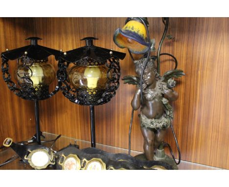 A SPELTER CHERUB TABLE LAMP, A PAIR OF MATCHING BLACK METAL TABLE LAMPS AND THREE HORSE BRASS LEATHER STRAPS (LAMPS IN WORKIN