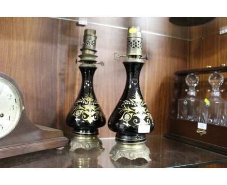 A PAIR OF FRENCH GILT METAL MOUNTED BLACK CERAMIC OIL LAMPS 
