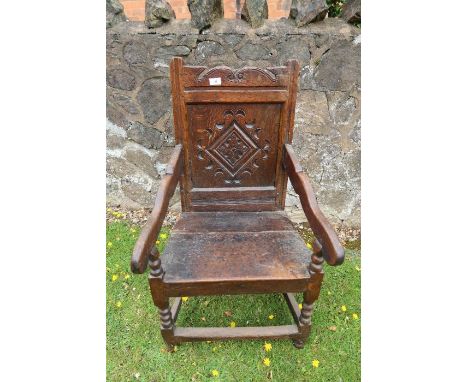 An antique oak Wainscote chair with the back panel having carved decoration.&nbsp;