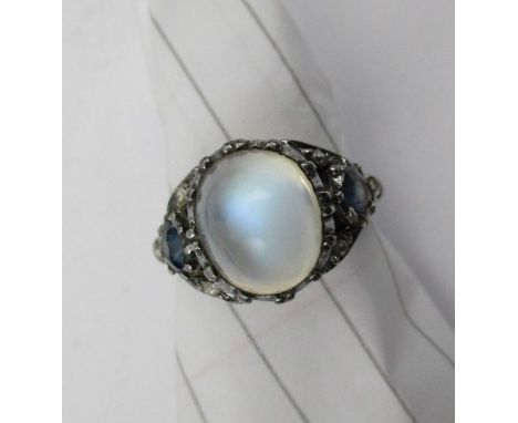 An Arts and Crafts ring, set with central moonstone, with sapphire and rose-cut diamond, to each shoulder, attributed Sibyl D