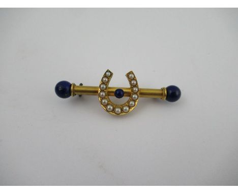 A Victorian bar brooch, mounted with a pearl set horseshoe with lapis lazuli ball and lapis lazuli balls to the end
