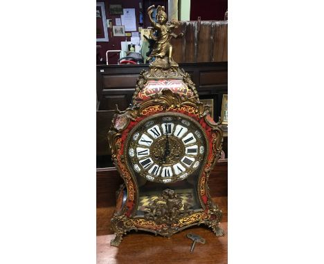 Antique red tortoiseshell Boulle cased mantel clock, designed with ormolu mounts. The dial with enamel cartouches with Roman 