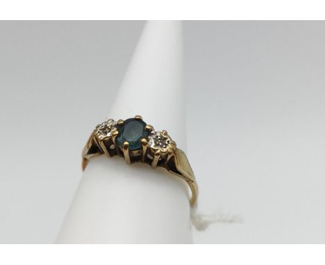 A Ladies 9ct gold ring centred with a green stone with diamond shoulders. Ring size K1/2 and weighs 1.8grams 