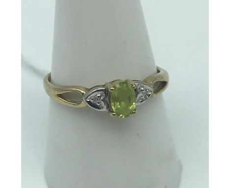 A Ladies 9ct gold ring set with a single Peridot cut stone and two single round diamonds to each shoulder.Ring size P and wei