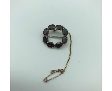 A Georgian or Victorian gold brooch set with 8 Amethyst stones. Weighs 3.5grams. Stones measure 4.5x6mm approx each. 