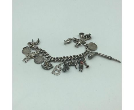 Antique heavy silver charm bracelet with 17 various silver charms which includes robot with movable joints, Coke bottle carry