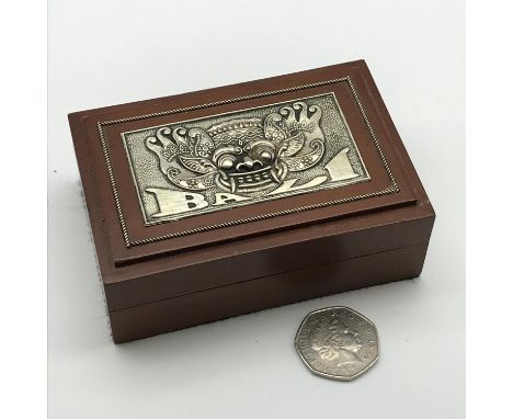 A Silver topped and wood Bali playing card box. Measures 4x10.5x7cm 