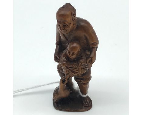 A Highly carved Japanese netsuke figure of an elderly gentleman carrying a child in a basket and a goose biting the basket. S