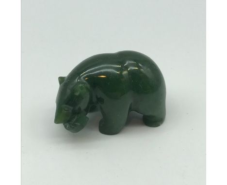 A Canadian hand carved Jade bear figure holding a fish in its mouth. Measures 3x5x3cm 