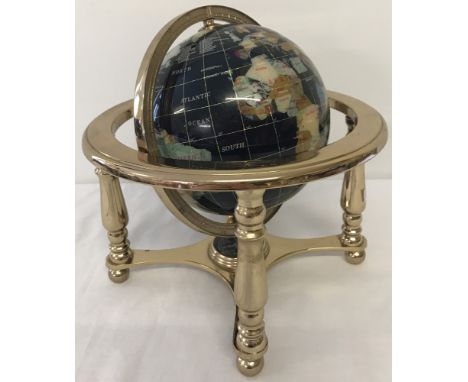 A gemstone globe in brass effect frame.  Diameter of globe approx. 14cm. Total height in frame approx. 24cm.