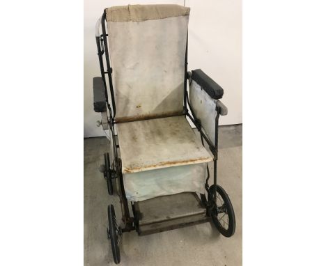 A vintage metal framed invalid chair with canvas material seating. With adjustable back and foot rest and sprung suspension. 