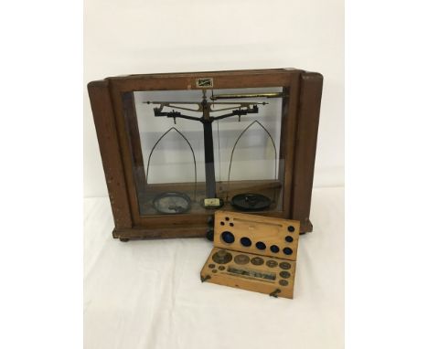 A vintage scientific scales with a box set of weights by Gallenkamp. Complete with glass case. 