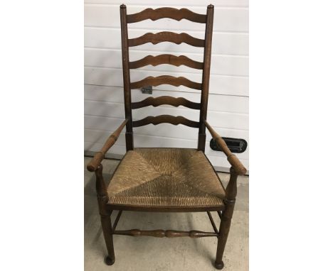 A vintage rush seated, high ladder backed carver with turned detail to front legs and arms.  