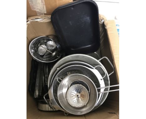 A box of vintage and new metal baking trays, flan dishes and cake tins.  