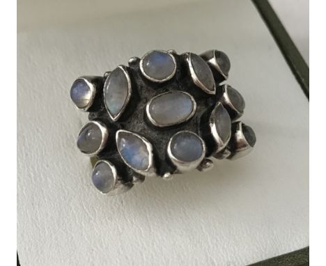 A silver dress ring set with 13 round, oval and marquise cut cabochon moonstones.  Size N 1/2.