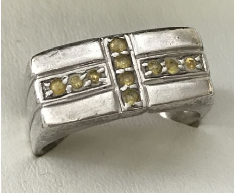 A men's silver ring set with 10 yellow stones to top in cross design. Stamped 925. Size V.