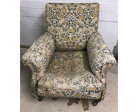 A Victorian armchair with wooden legs and ceramic castors. In need of attention. 