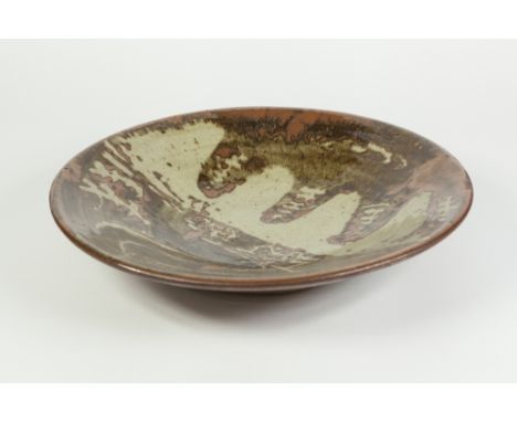 A BERNARD LEACH (ST. IVES, CORNWALL) GLAZED STONEWARE STUDIO POTTERY SHALLOW DISH, decorated with an abstract design in mottl