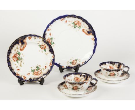 TWELVE EARLY TWENTIETH CENTURY CHINA TEACUPS AND SAUCERS 'Rococo and Poppy' PATTERN, in iron red, dark blue green and gilt to
