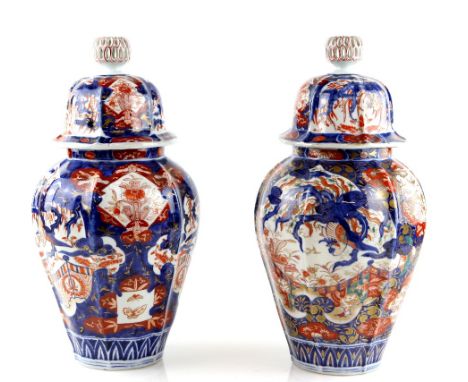 An associated pair of Japanese Imari vases; each one with domed cover and reticulated knop finial, and decorated on each side