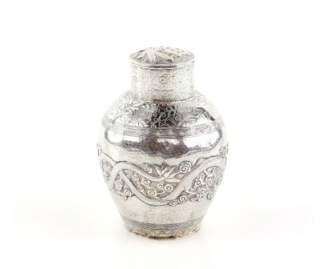 A Chinese white metal, oviform tea caddy and and cylindrical cover;  decorated with a bold design of dragons chasing a flamin