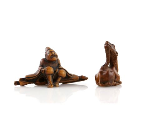 Two wood netsuke, comprising: a seated traveller wearing waraji, 7 cm long; and a seated kirin with its head raised into the 