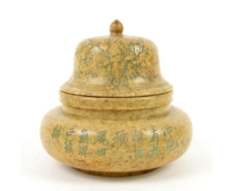 A soapstone vase with domed cover and knop finial, decorated on the exterior with a poem, or other text, beside floral design