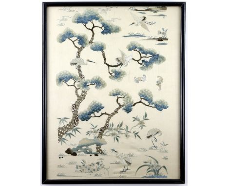A Chinese silk panel embroidered with The Daoist theme of Cranes, flying through pine trees, framed and glazed, 41cm x 31.5cm