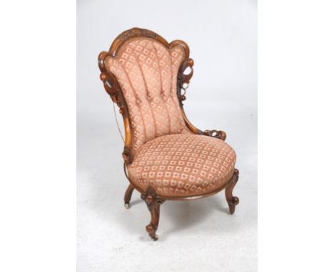 A Victorian walnut and upholstered drawing room chair
With an arched back carved with scrolls and leaves, leaf carved scrolli
