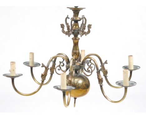 A brass six branch chandelier 
The baluster shaft with sea serpents above six scrolling dolphin branches with a sphere and ri