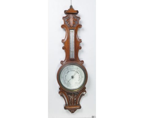 A Victorian oak aneroid wheel barometer
With a 20cm silvered register above a thermometer the shaped case with a leaf carved 