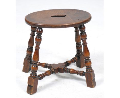 An oak and beechwood joint stool
The oval top with carry aperture to centre raised upon baluster bobbin and ring turned legs 