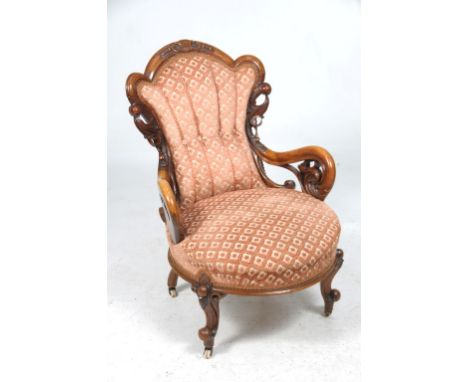 A Victorian walnut drawing room chair
With an arched moulded back carved with scrolling leaves, open leaf carved scrolling ar