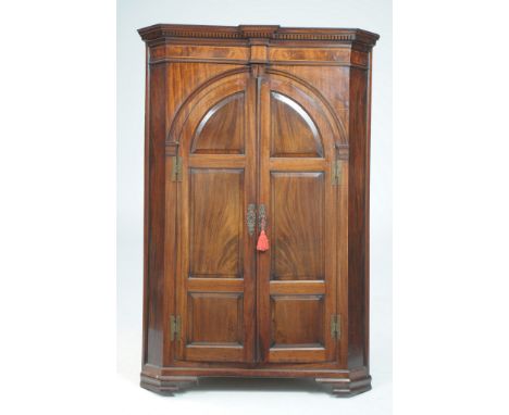 A fine George III mahogany freestanding corner wall cupboard
With a break front dentil cornice above an inlaid frieze with a 