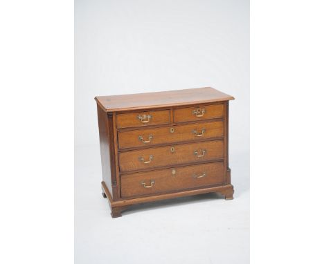 A George III oak chest of drawers
With a rectangular moulded one piece top above two short and three long graduated cock bead