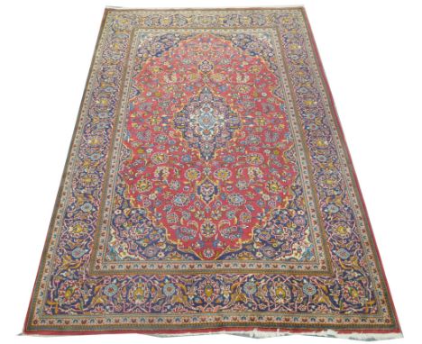 An Iranian carpet
With guard stripes, flower and leaf border the central rectangular red field with a shaped foliate medallio