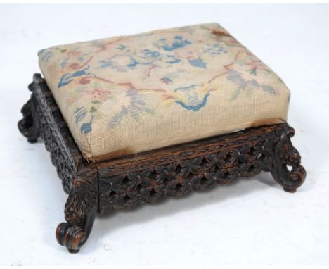 A Ceylonese hardwood stool
With a padded tapestry seat the frieze pierced with interlaced ovals and flowers, leaf and fruit d