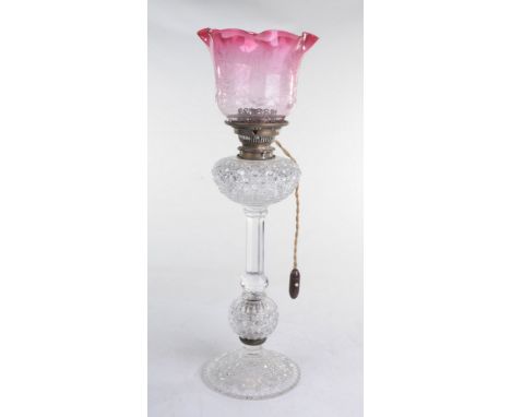 A choice cut glass table lamp
With a ruby tinted acid etched, tulip shape shade supported on a converted burner above a cut g