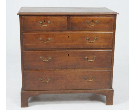 An early 19th Century oak chest of drawers
The rectangular two plank top with a moulded border above two short and three long