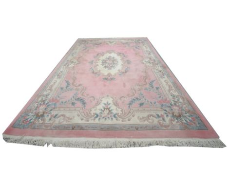 A Chinese wool carpet
The pink ground with a foliate medallion leaf and rose spandrels against a cream outer border tasselled