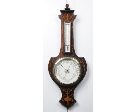 An Edwardian inlaid mahogany aneroid barometer
With a 19cm ceramic register with blued hands above a thermometer, the case wi