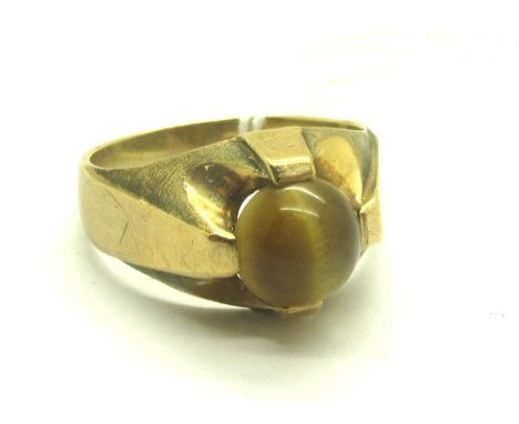 A 9ct Gold Cabochon Cat's Eye Gemstone Ring, compass set between faceted style band (finger size R1/2) (4.2grams).