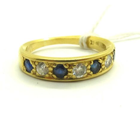 A Stone Set Half Eternity Style Ring, alternate inset stones, within plain border, indistinctly stamped "18ct". (finger size 