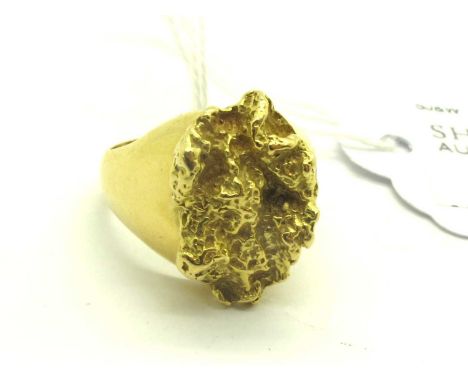 An Abstract Signet Style Ring, the oval centre panel with abstract textured finish, between chunky tapered shoulders, stamped