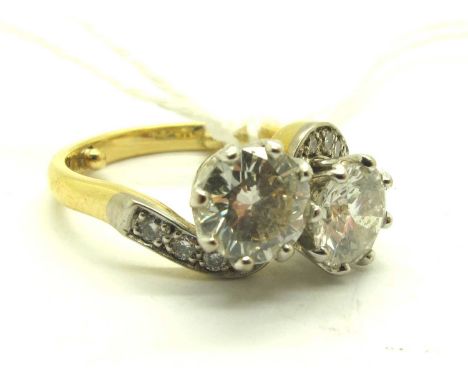 An 18ct Gold Two Stone Diamond Crossover Ring, the claw set diamonds between diamond set shoulders and uniform band, (approxi