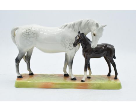 Beswick Mare and Foal - grey mare with dark brown foal on ceramic grass base 1811. In good condition with no obvious damage o